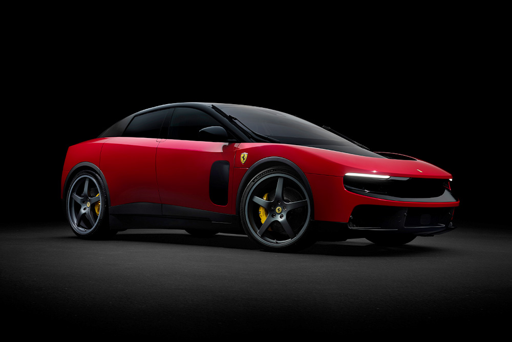 The sleek red Ferrari Luce electric sedan concept car displayed at a side three-quarter angle on a black backdrop.