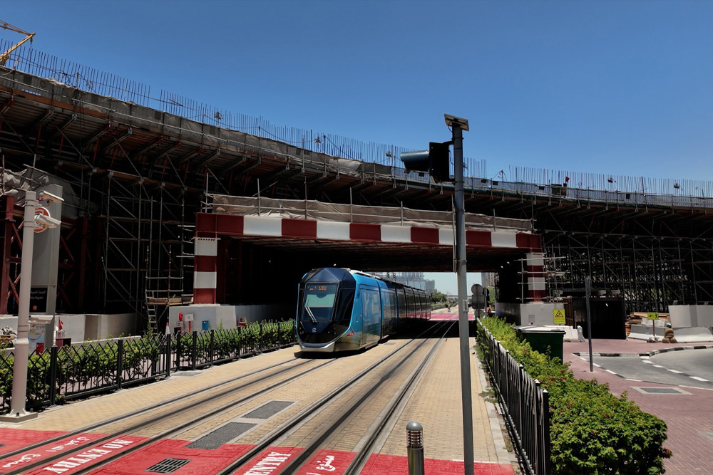 Dubai Tram passing beneath an urban infrastructure project, highlighting modern public transportation and city development