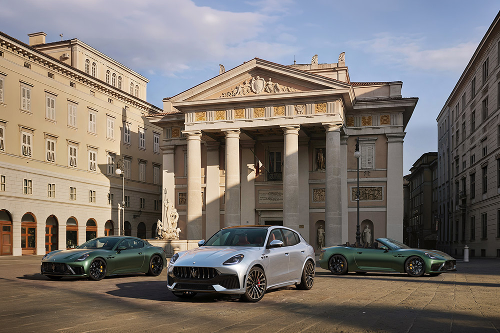 Three luxury Maserati sports cars and SUVs parked on a stone plaza in front of a historic building.