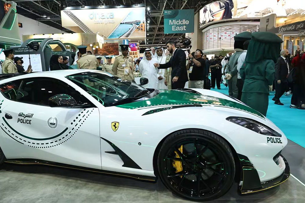 Showcase display of a white and green Dubai Police Ferrari 812 Superfast supercar at a travel trade expo