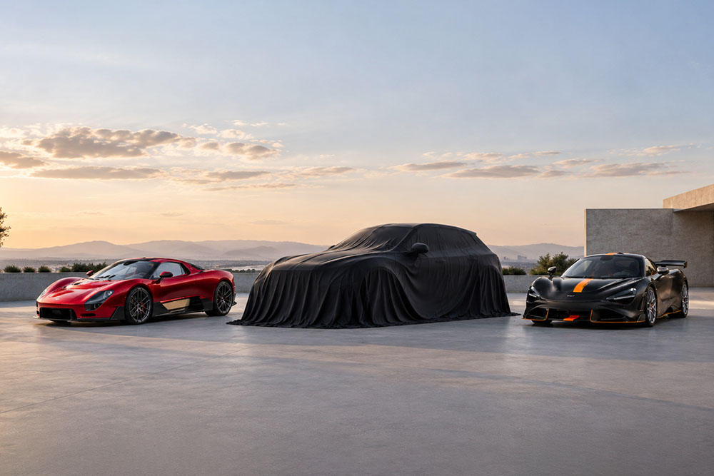 A draped prototype SUV flanked by two exposed sports cars on an open-air terrace